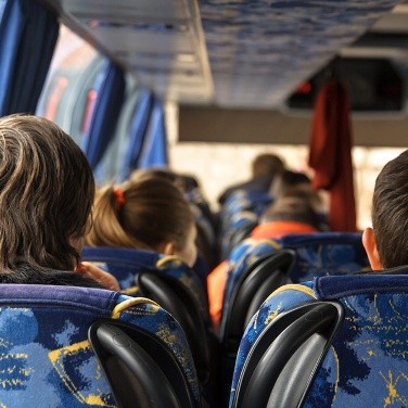 Enfants assis de dos dans un car scolaire, illustration des accidents transport scolaire 2025